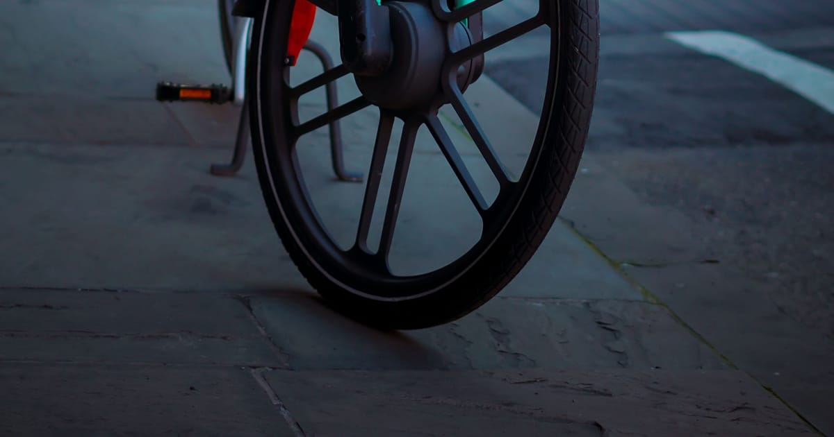 An electric bike with a hub motor, parked on a city street at dusk