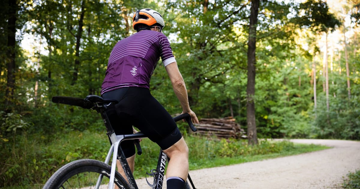 A rider on a road bike on a forest road