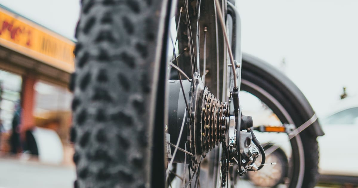 A knobbly bicycle tyre from ground level, tread and rim in focus